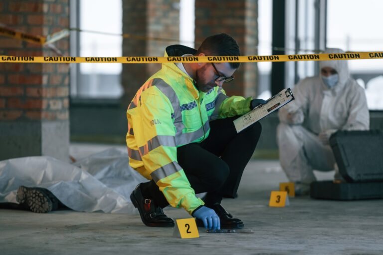 Detectives are collecting evidence in a crime scene near dead body. Forensic specialists